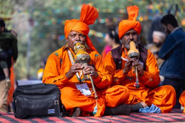 Faridabad, Haryana, Hindistan - Şubat 04: 2023: Turistleri cezbetmek için etnik elbise giymiş surajkund zanaat fuarı sırasında erkek yılan oynatıcıların portresi