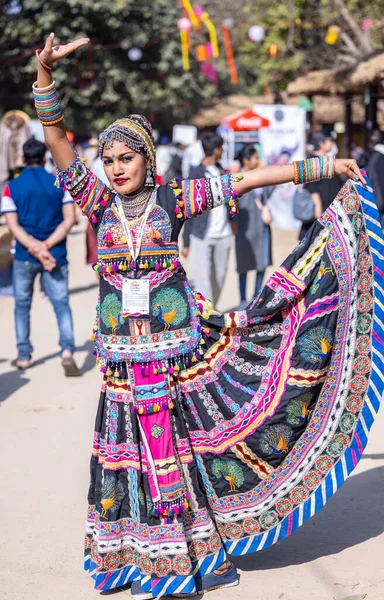 Faridabad, Haryana, Hindistan - Şubat 04 2023: Surajkund sanat fuarında geleneksel elbiseler içinde dans eden bir kadın sanatçının portresi.