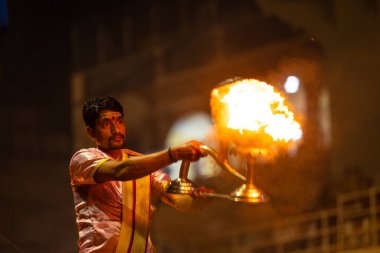 Varanasi, Uttar Pradesh, Hindistan - 3 Mart 2023: Ganga aarti, Dashashwamedh ghat geleneksel elbise ve Hindu ayinleri ile kutsal nehir ganges akşam aarti performans genç rahip portresi