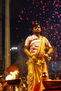 Varanasi, Uttar Pradesh, Hindistan - 3 Mart 2023: Ganga aarti, Dashashwamedh ghat geleneksel elbise ve Hindu ayinleri ile kutsal nehir ganges akşam aarti performans genç rahip portresi