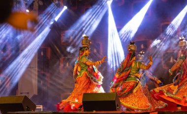 Puşkar, Rajasthan, Hindistan - Kasım 05 2022: Rajasthani halk dansları yapan kadın sanatçılar geleneksel renkli elbiseler ve Pushkar Fuarı 'nda kafası yanan metal kaplarla Ghoomar' ı canlandırıyorlar. Seçici odak