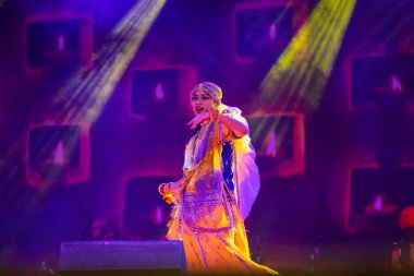 Puşkar, Rajasthan, Hindistan - 05 Kasım 2022: Renkli bir etnik rajasthani elbisesi içinde pulkar fuarında dans eden genç ve güzel kadın sanatçının portresi. Sanatçıya Seçici Odaklanma