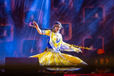 Puşkar, Rajasthan, Hindistan - 05 Kasım 2022: Renkli bir etnik rajasthani elbisesi içinde pulkar fuarında dans eden genç ve güzel kadın sanatçının portresi. Sanatçıya Seçici Odaklanma