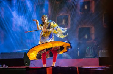 Puşkar, Rajasthan, Hindistan - 05 Kasım 2022: Renkli bir etnik rajasthani elbisesi içinde pulkar fuarında dans eden genç ve güzel kadın sanatçının portresi. Sanatçıya Seçici Odaklanma