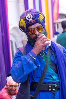 Anandpur Sahib, Punjab, Hindistan - 19 Mart 2022: Holi festivali sırasında Anandpur Sahib 'de düzenlenen Hola Mohalla kutlamaları sırasında bir grup sikh erkek (Nihang Sardar). Renkli yüze seçici odaklanma.