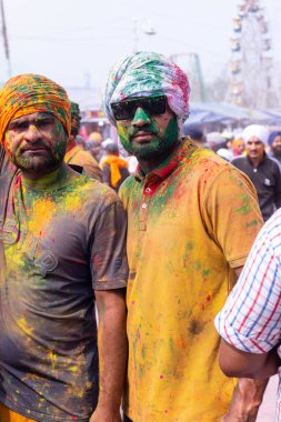 Anandpur Sahib, Punjab, Hindistan - 19 Mart 2022: Holi festivali sırasında Anandpur Sahib 'de düzenlenen Hola Mohalla kutlamaları sırasında bir grup sikh erkek (Nihang Sardar). Renkli yüze seçici odaklanma.