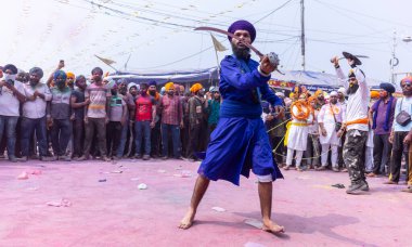 Anandpur Sahib, Punjab, Hindistan - 19 Mart 2022: Holi festivali sırasında Hola Mohalla 'nın Anandpur Sahib' te kutlaması sırasında Sih erkek portresi (Nihang Sardar) dövüş sanatlarını kültür olarak icra etti
