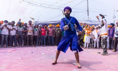 Anandpur Sahib, Punjab, Hindistan - 19 Mart 2022: Holi festivali sırasında Hola Mohalla 'nın Anandpur Sahib' te kutlaması sırasında Sih erkek portresi (Nihang Sardar) dövüş sanatlarını kültür olarak icra etti 