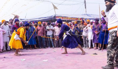 Anandpur Sahib, Punjab, Hindistan - 19 Mart 2022: Holi festivali sırasında Hola Mohalla 'nın Anandpur Sahib' te kutlaması sırasında Sikh erkek (Nihang Sardar) portresi dövüş sanatlarını kültür olarak icra ediyor