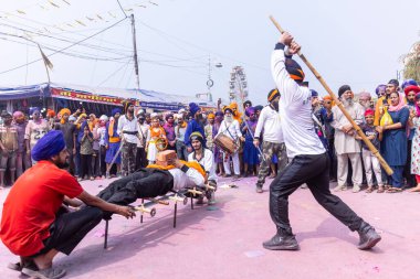 Anandpur Sahib, Punjab, Hindistan - 19 Mart 2022: Holi festivali sırasında Hola Mohalla 'nın Anandpur Sahib' te kutlaması sırasında Sikh erkek (Nihang Sardar) portresi dövüş sanatlarını kültür olarak icra ediyor