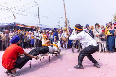 Anandpur Sahib, Punjab, Hindistan - 19 Mart 2022: Holi festivali sırasında Hola Mohalla 'nın Anandpur Sahib' te kutlaması sırasında Sikh erkek (Nihang Sardar) portresi dövüş sanatlarını kültür olarak icra ediyor
