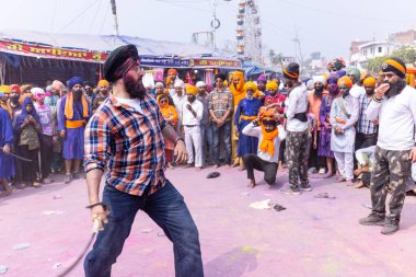 Anandpur Sahib, Punjab, Hindistan - 19 Mart 2022: Holi festivali sırasında Hola Mohalla 'nın Anandpur Sahib' te kutlaması sırasında Sikh erkek (Nihang Sardar) portresi dövüş sanatlarını kültür olarak icra ediyor
