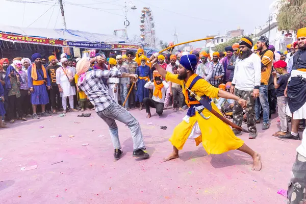 Anandpur Sahib, Punjab, Hindistan - 19 Mart 2022: Holi festivali sırasında Hola Mohalla 'nın Anandpur Sahib' te kutlaması sırasında Sikh erkek (Nihang Sardar) portresi dövüş sanatlarını kültür olarak icra ediyor