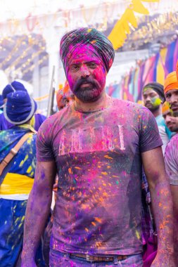 Anandpur Sahib, Punjab, Hindistan - 19 Mart 2022: Holi festivali sırasında Anandpur Sahib 'de düzenlenen Hola Mohalla kutlamaları sırasında bir grup sikh erkek (Nihang Sardar). Renkli yüze seçici odaklanma.