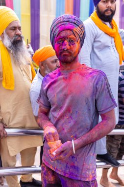 Anandpur Sahib, Punjab, Hindistan - 19 Mart 2022: Holi festivali sırasında Anandpur Sahib 'de düzenlenen Hola Mohalla kutlamaları sırasında bir grup sikh erkek (Nihang Sardar). Renkli yüze seçici odaklanma.