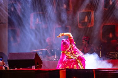 Puşkar, Rajasthan, Hindistan - 05 Kasım 2022: Pushkar Fuarı 'nda geleneksel renkli elbiseyle Rajasthani halk dansı yapan kadın sanatçının portresi