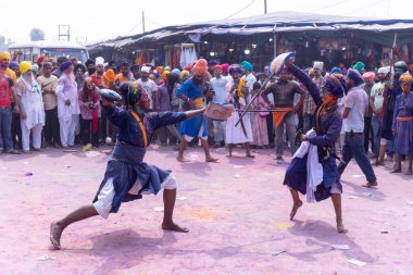 Anandpur Sahib, Punjab, Hindistan - 19 Mart 2022: Holi festivali sırasında Hola Mohalla 'nın Anandpur Sahib' te kutlaması sırasında Sih erkek portresi (Nihang Sardar) dövüş sanatlarını kültür olarak icra etti