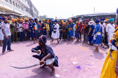 Anandpur Sahib, Punjab, Hindistan - 19 Mart 2022: Holi festivali sırasında Hola Mohalla 'nın Anandpur Sahib' te kutlaması sırasında Sih erkek portresi (Nihang Sardar) dövüş sanatlarını kültür olarak icra etti