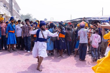 Anandpur Sahib, Punjab, Hindistan - 19 Mart 2022: Holi festivali sırasında Hola Mohalla 'nın Anandpur Sahib' te kutlaması sırasında Sih erkek portresi (Nihang Sardar) dövüş sanatlarını kültür olarak icra etti