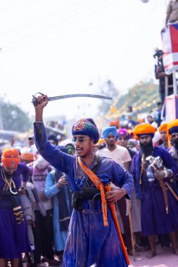 Anandpur Sahib, Punjab, Hindistan - 19 Mart 2022: Holi festivali sırasında Hola Mohalla 'nın Anandpur Sahib kutlamaları sırasında Sikh Adam' ın (Nihang Sardar) dövüş sanatlarını kültür olarak sergilemesi 