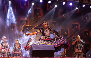 Puşkar, Rajasthan, Hindistan - Kasım 05 2022: Rajasthani halk dansları yapan kadın ressamın portresi geleneksel elbisesiyle pulkar fuarında gülümseyerek 