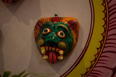 El yapımı renkli bir kabile hayvan maskesi. Arka planda asılı. 