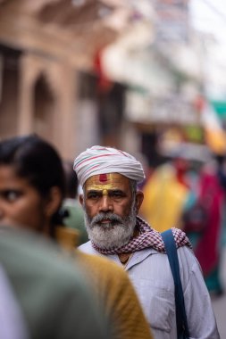 Puşkar, Rajasthan, Hindistan - Kasım 06 2022: Puşkar Fuarı, deve fuarı sırasında Pushkar caddesinde yaşlı bir sadhu babanın portresi