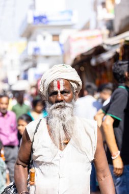 Puşkar, Rajasthan, Hindistan - Kasım 06 2022: Puşkar Fuarı, deve fuarı sırasında Pushkar caddesinde yaşlı bir sadhu babanın portresi