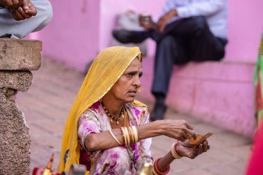 Puşkar, Rajasthan, Hindistan - Kasım 05 2022: Puşkar Fuarı, Rajasthan 'lı kadın portresi Renkli geleneksel elbise ve başörtüsü