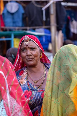 Puşkar, Rajasthan, Hindistan - Kasım 05 2022: Puşkar Fuarı, Rajasthan 'lı kadın portresi Renkli geleneksel elbise ve başörtüsü