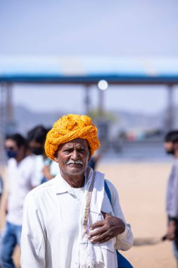 Puşkar, Rajasthan, Hindistan - Kasım 06 2022: Puşkar Fuarı, Rajasthani 'nin beyaz geleneksel elbisesi ve renkli türbanlı portresi
