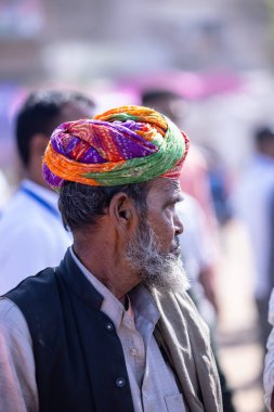 Puşkar, Rajasthan, Hindistan - Kasım 06 2022: Puşkar Fuarı, Rajasthani 'nin beyaz geleneksel elbisesi ve renkli türbanlı portresi