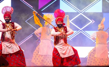 Bikaner, Rajasthan, Hindistan - 14 Ocak 2023: Punjab 'dan bir grup Punjab sanatçısı bikaner deve festivalinde geleneksel renkli giysiler içinde bhangra dansı yapıyorlar