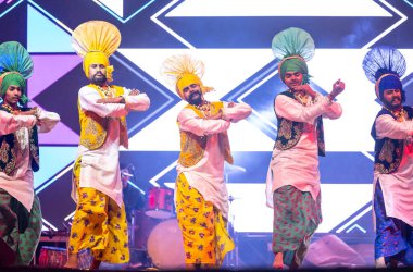 Bikaner, Rajasthan, Hindistan - 14 Ocak 2023: Punjab 'dan bir grup Punjab sanatçısı bikaner deve festivalinde geleneksel renkli giysiler içinde bhangra dansı yapıyorlar