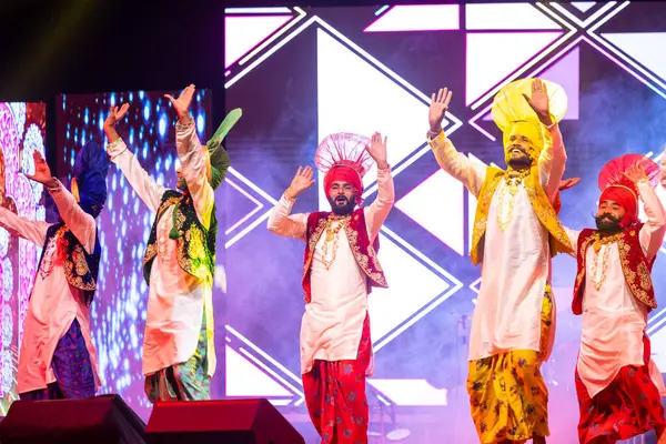 Bikaner, Rajasthan, Hindistan - 14 Ocak 2023: Punjab 'dan bir grup Punjab sanatçısı bikaner deve festivalinde geleneksel renkli giysiler içinde bhangra dansı yapıyorlar