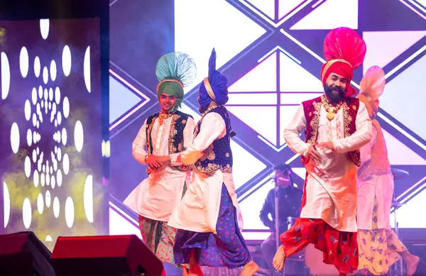 Bikaner, Rajasthan, Hindistan - 14 Ocak 2023: Punjab 'dan bir grup Punjab sanatçısı bikaner deve festivalinde geleneksel renkli giysiler içinde bhangra dansı yapıyorlar