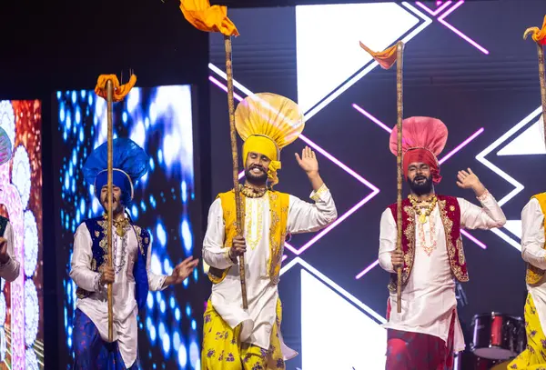 stock image Bikaner, Rajasthan, India - January 14, 2023: Group of punjabi artists from punjab performing bhangra dance in traditional colourful clothes at bikaner camel festival