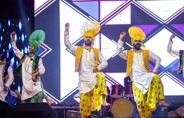 stock image Bikaner, Rajasthan, India - January 14, 2023: Group of punjabi artists from punjab performing bhangra dance in traditional colourful clothes at bikaner camel festival