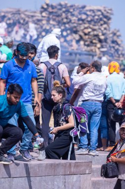 Varanasi, Uttar Pradesh, Hindistan - 04 Mart 2023: Masan Holi, Mankarnika ghat 'ındaki bayram bayramını renklerle ve eğlenceyle kutlayan kimliği belirsiz bir grup insan. Holi festivalinde mutlu yüzler