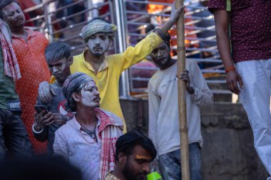Varanasi, Uttar Pradesh, Hindistan - 04 Mart 2023: Masan Holi, Mankarnika ghat 'ındaki bayram bayramını renklerle ve eğlenceyle kutlayan kimliği belirsiz bir grup insan. Holi festivalinde mutlu yüzler