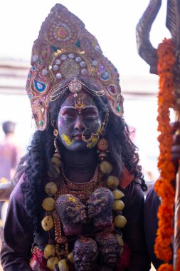 Varanasi, Uttar Pradesh, Hindistan - Mart 04, 2023: Masan Holi, Varanasi 'deki manikarnika ghat' ında Masabika Holi 'nin kutlaması sırasında tanrıça olarak yüzünü boyamış bir kadın sanatçının portresi