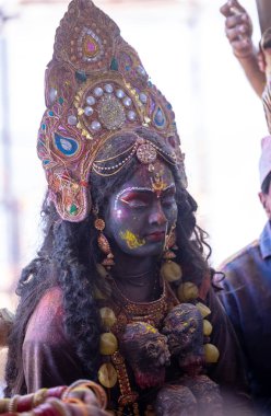 Varanasi, Uttar Pradesh, Hindistan - Mart 04, 2023: Masan Holi, Varanasi 'deki manikarnika ghat' ında Masabika Holi 'nin kutlaması sırasında tanrıça olarak yüzünü boyamış bir kadın sanatçının portresi