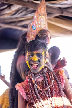 Varanasi, Uttar Pradesh, Hindistan - Mart 04: 2023: Masan Holi, kimliği belirlenemeyen bir çocuğun portresi, Karnika ghat 'ında kutlanıyor. Holi festivalinde mutlu yüzler
