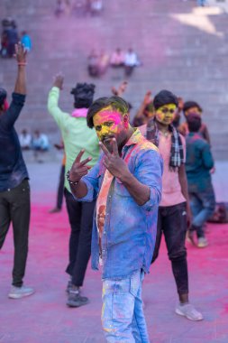 Varanasi, Uttar Pradesh, Hindistan - 04 Mart 2023: Masan Holi, Mankarnika ghat 'ındaki bayram bayramını renklerle ve eğlenceyle kutlayan kimliği belirsiz bir grup insan. Holi festivalinde mutlu yüzler