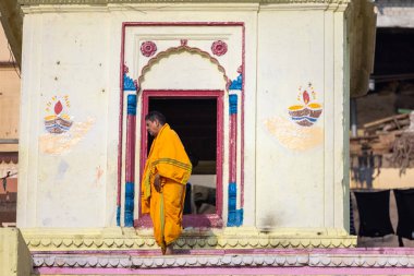 Varanasi, Uttar Pradesh, Hindistan - 05 Mart 2023: Varanasi 'deki çetelerin yakınındaki ghatlarda yürüyen geleneksel sadhu baba resmi