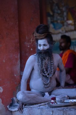 Varanasi, Uttar Pradesh, Hindistan - 05 Mart 2023: Varanasi 'deki çetelerin yakınındaki Dashashwamedh ghat' ta oturan yaşlı kutsal Naga sadhu baba 'nın portresi
