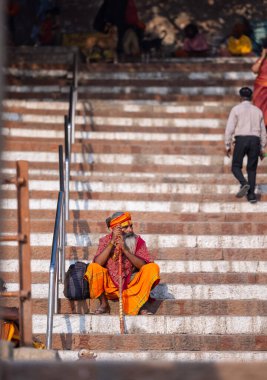 Varanasi, Uttar Pradesh, Hindistan - 05 Mart 2023: Varanasi 'deki çetelerin yakınındaki ghatlarda oturan geleneksel kutsal sadhu baba resmi. Kashi en eski ve kutsal şehir.