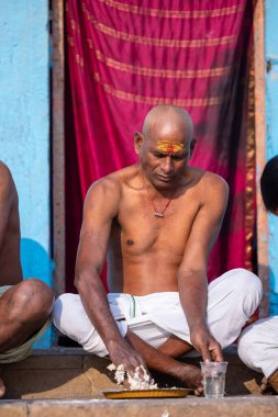 Varanasi, Uttar Pradesh, Hindistan - 05 Mart 2023: Varanasi 'deki nehir çetelerinin yakınlarındaki Kedar ghat' ta tanımlanamayan Brahmin Güney Hint erkeklerinin portresi