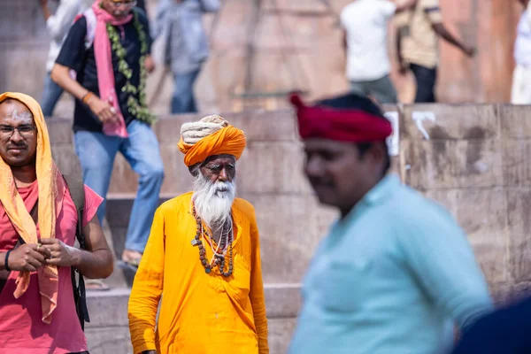 Stock image Varanasi, Uttar Pradesh, India - March 05, 2023: Portrait of old holy sadhu baba in traditional dress walking on the ghats near ganges in varanasi