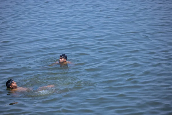 stock image Varanasi, Uttar Pradesh, India - March 05 2023: Portrait of young men swimming in river ganges for fun.